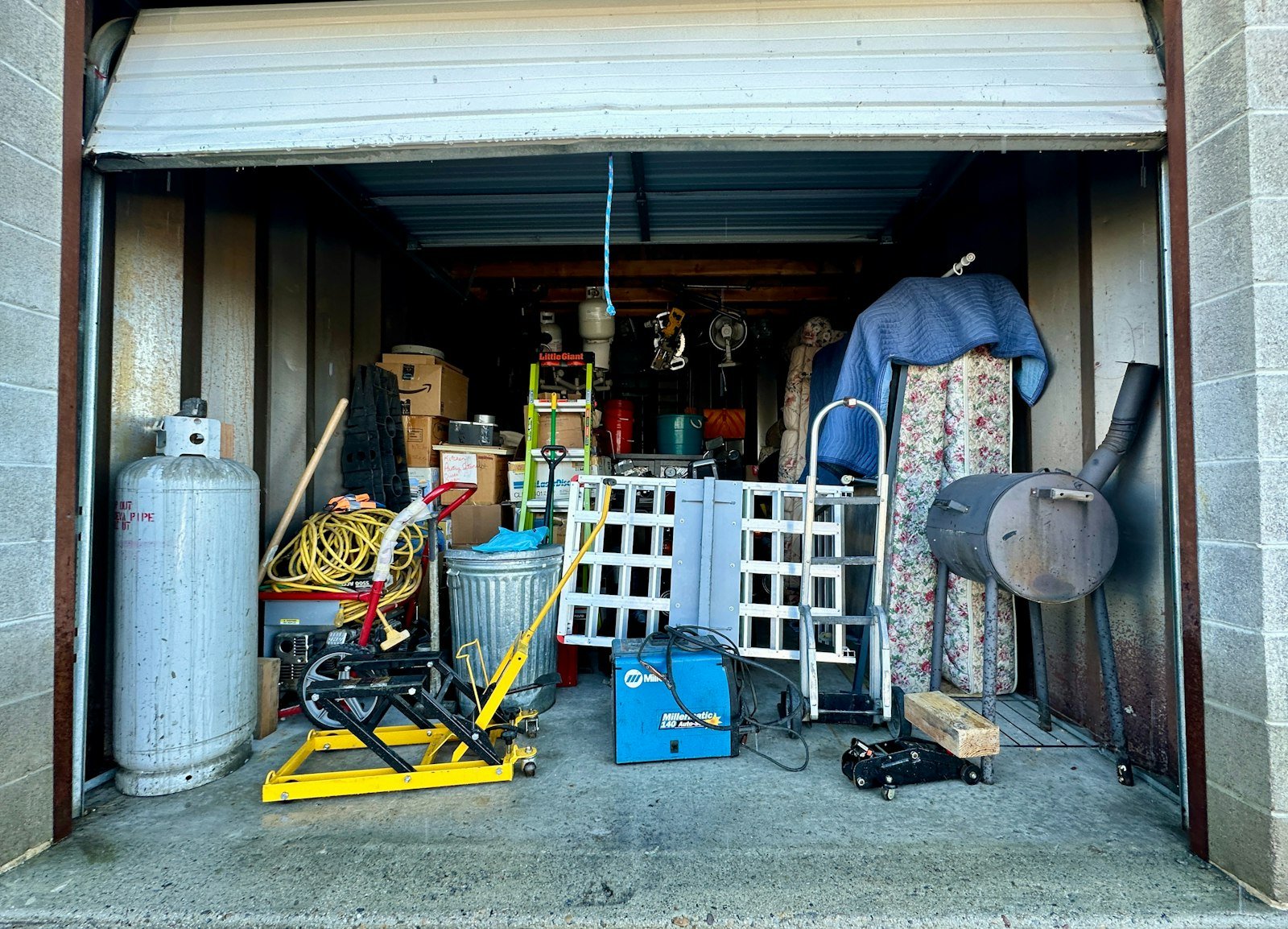 Storage unit packed with furniture, tools and boxes